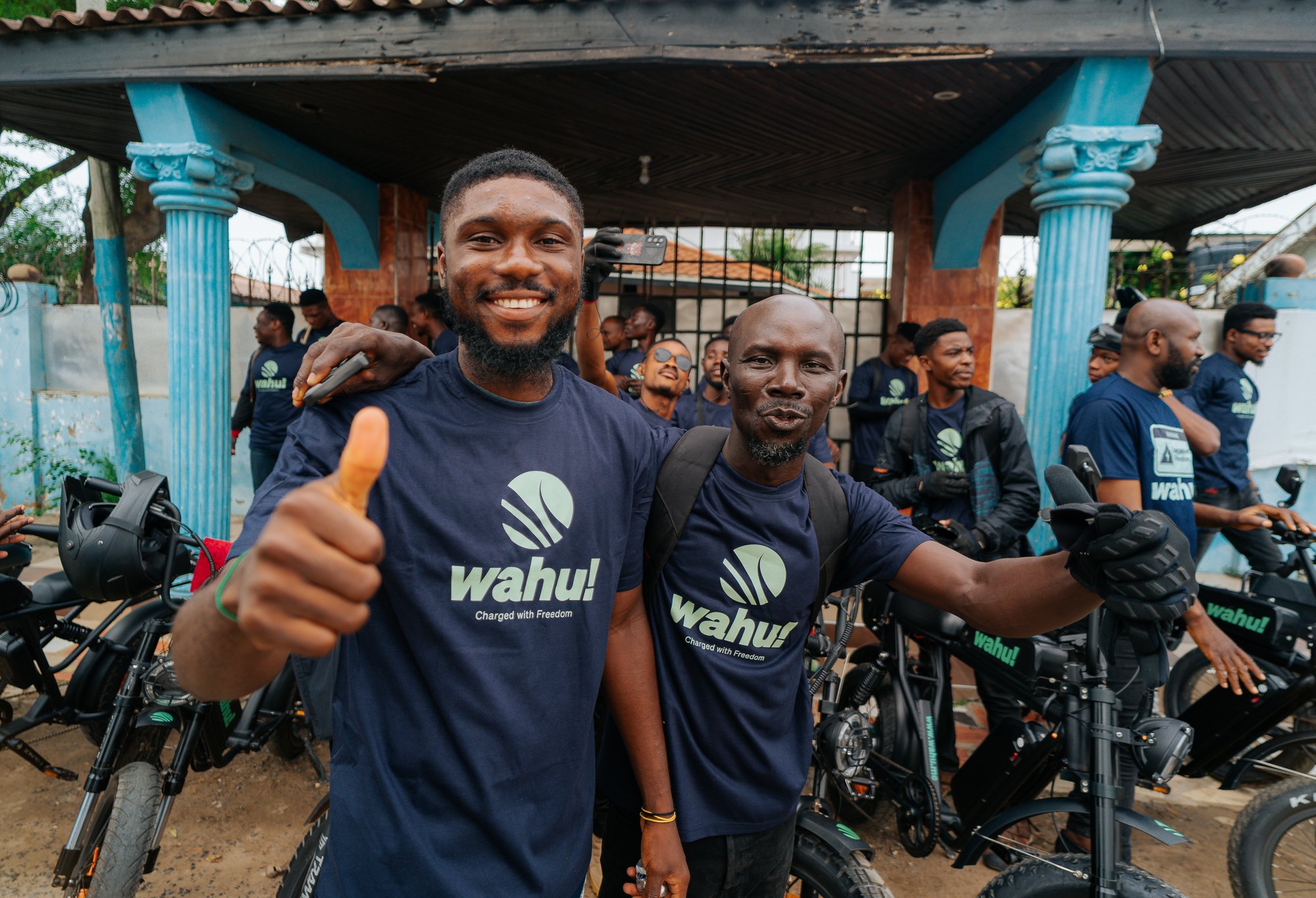 Two Wahu riders giving thumbs up next to their eMotos