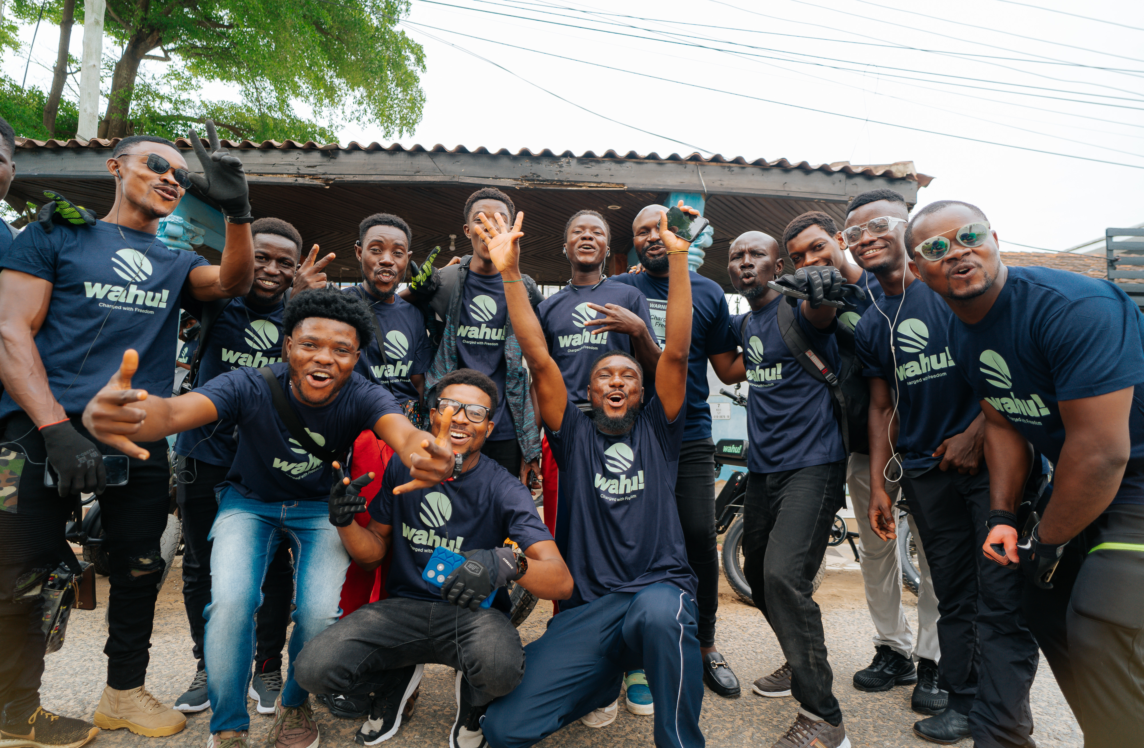 A group of Wahu riders posing together in branded shirts