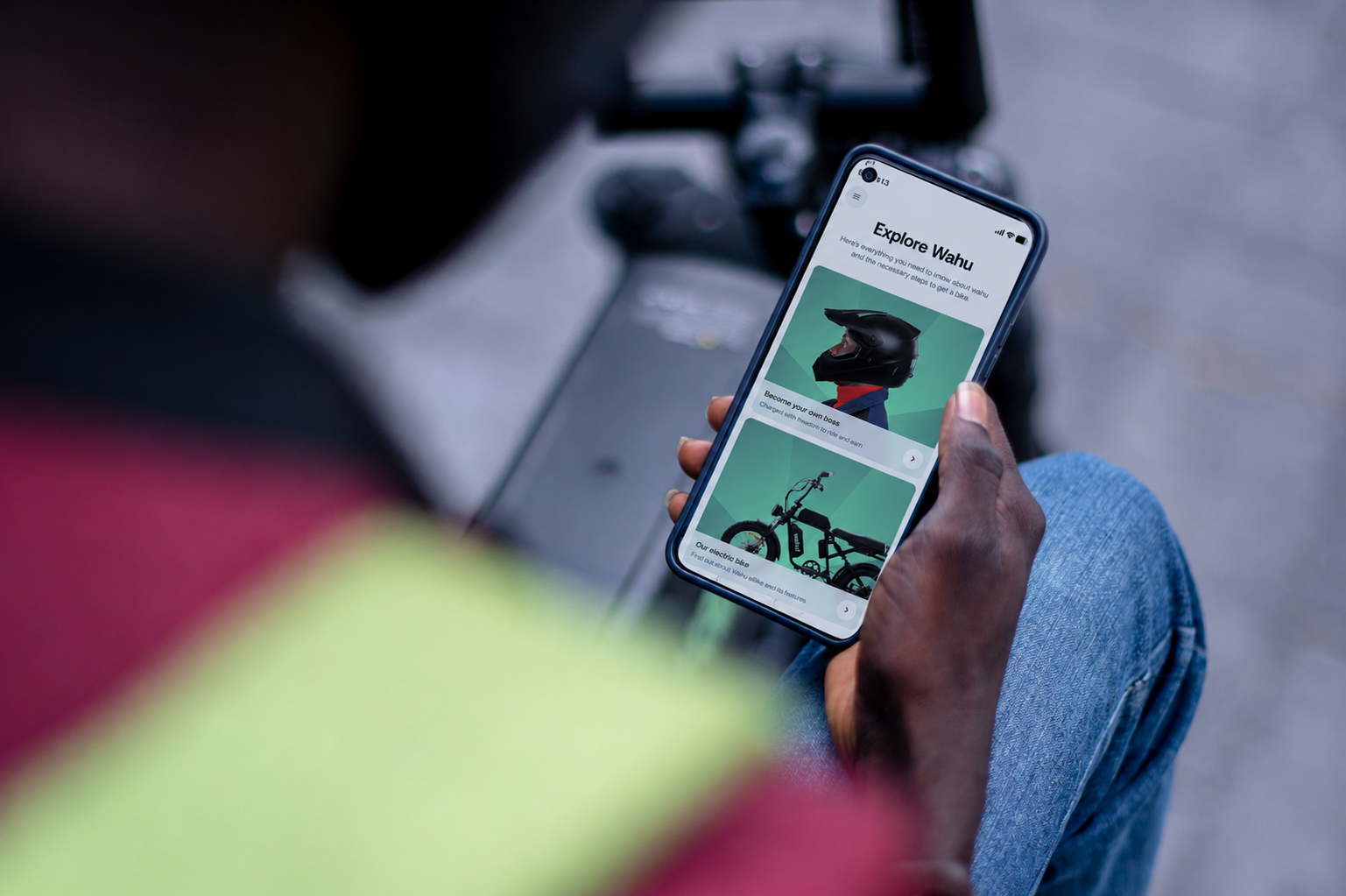 A Wahu rider checking the Hero app on their phone, sitting on the eBike